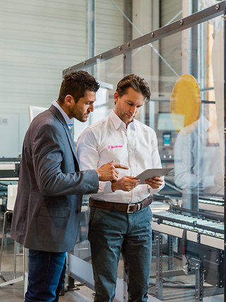 Two men with a tablet on the production line.