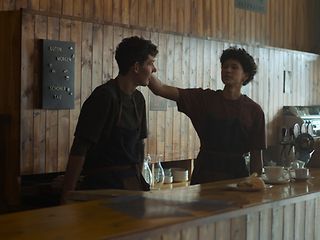 The picture shows two people facing and supporting each other.