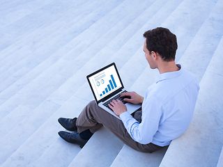 Man with a laptop sitting on stairs.