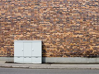 A street cabinet in front of a residential building.
